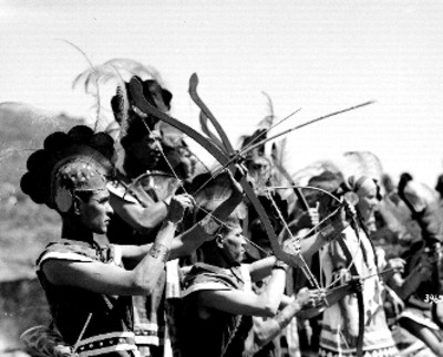 Danzantes indígenas con arcos durante fiesta, retrato de grupo