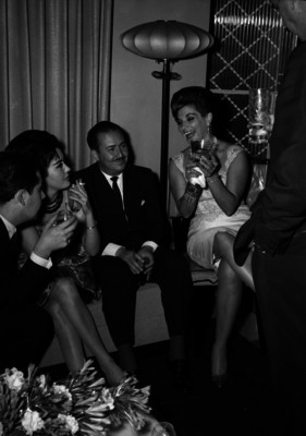Carlos Román Celis conviviendo con hombres y mujeres durante un evento social en una casa