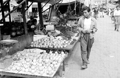 Ladrón de frutas pasa frente a un puesto