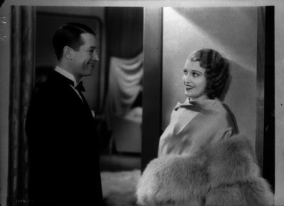 Maurice Chevalier con una actirz durante la filmación de una escena cinematográfica