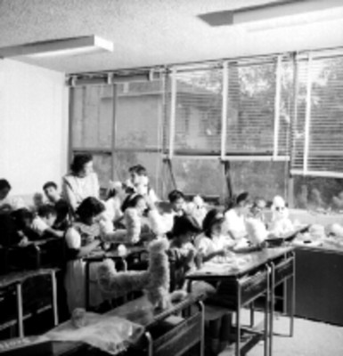 Alumnos realizan trabajos manuales en un aula