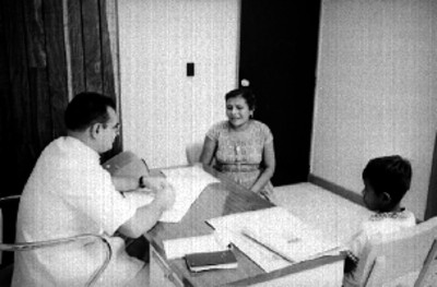 Médico da consulta a mujer y niño