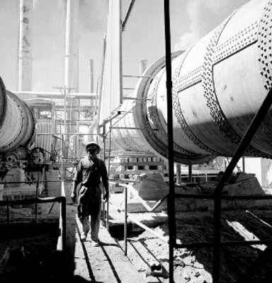 Obrero camina por las instalaciones de una fábrica de cemento