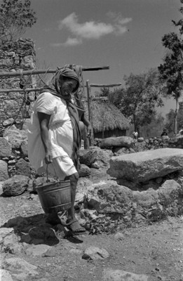 Mujer indígena acarrea agua