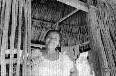 Mujer maya en entrada de una vivienda
