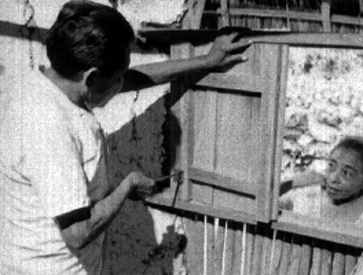 Hombre maya arregla ventana de vivienda