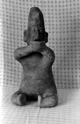 Figurilla antropomorfa en postura sedente con vasija entre sus manos