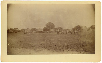 Hombres indígenas montados a caballo en un poblado, retrato de grupo
