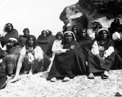 Hombres tarahumara sentados junto a una formación rocosa