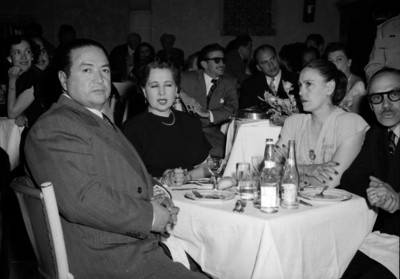 Antonio Gómez Velasco y esposa con varias personas ante una mesa durante un evento