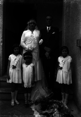 Enrique González y su novia en compañía de niños durante su boda, retrato de grupo