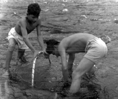 Pareja de jóvenes pescan en un río