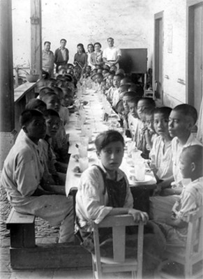 Niños de un orfanato tomando el desayuno