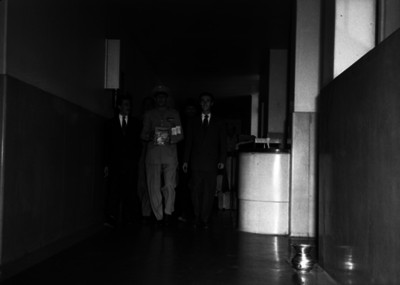 Adolfo León Osorio con funcionario, recorriendo los pasillos de un edificio público