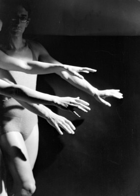 Bailarines con las manos extendidas hacia en frente escenifican una expresión artistica