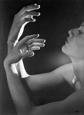 Bailarina de ballet con manos encorvadas hacia su rostro, expresión artistica