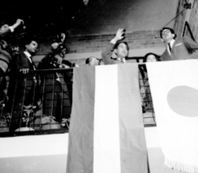 Akihito saluidando desde un balcón durante su visita la Unidad Independencia