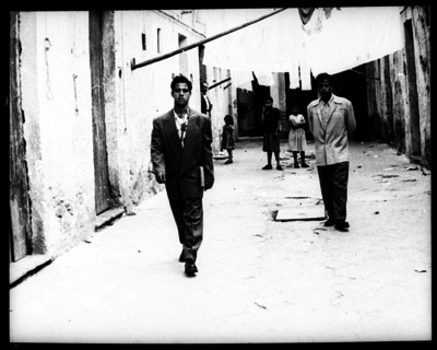 Raúl El Ratón Macías caminando en el patio de la vecindad donde vive