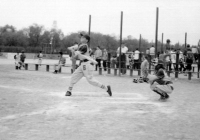 Equipo juvenil de la General Electric jugando beisbol en un campo deportivo