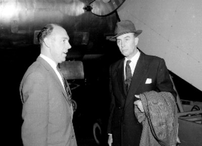 Pasajeros conversando frente a un avión