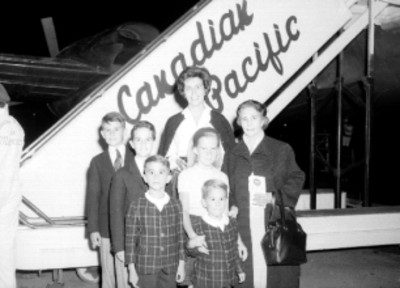 Mujeres con niños en el aeropuerto, junto a escaleras de un avión Canadian Pacific, retrato de grupo