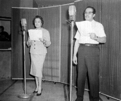 Locutor sirviéndose refresco, durante un programa de radio en un estudio