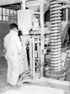 Obrero en la fábrica FERRO ENAMEL, trabajando con una máquina industrial