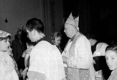 Sacerdote y obispo oficiando una ceremonia de confirmación en la iglesia
