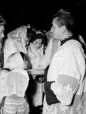 Mujeres y niñas ante un sacerdote en la iglesia, durante una confirmación