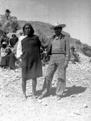 Mestizo y tarahumara junto a una formación rocosa, retrato