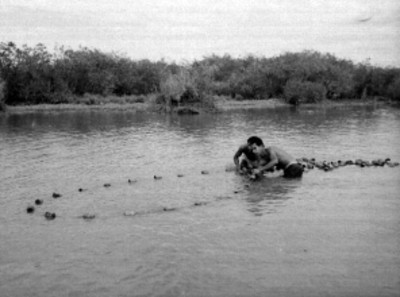 Hombres pescando con una red, en una laguna del municipio de San Blás