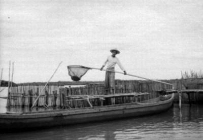 Pescadores con un utensilio para pescar, en la laguna del municipio de San Blás