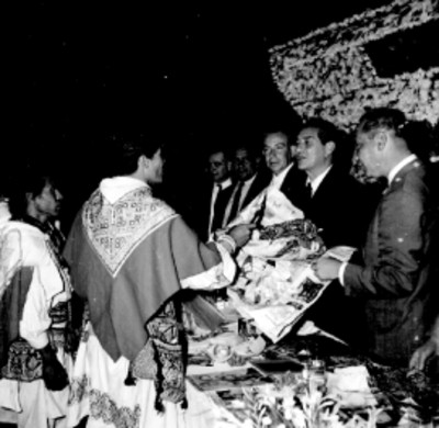 Adolfo López Mateos recibiendo una artesania textil departe de un grupo de huicholes en una ceremonia