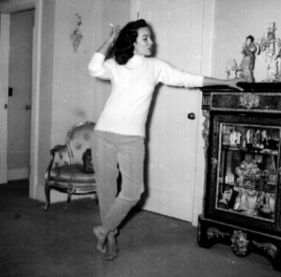 Hombres encendiendo cigarrillo a María Félix en una habitación