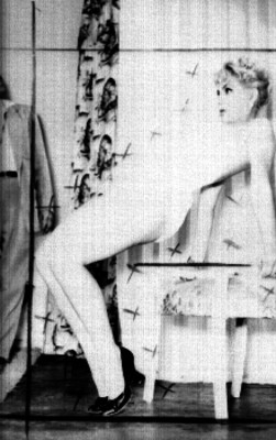 Modelo posando en traje de baño recargada sobre una silla en un estudio fotográfico