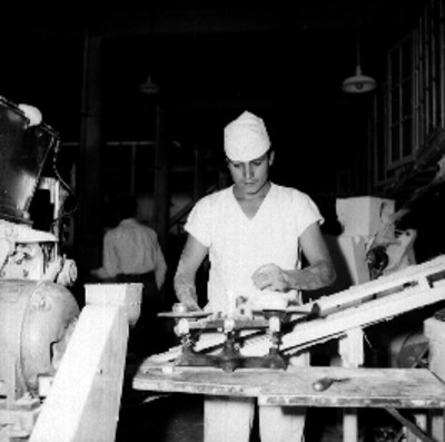 Panadero maniobrando una máquina, durante un proceso de elaboración de pan