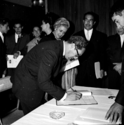 Adolescentes firmando libro de visitas en un salón, durante el Día Mundial del Urbanismo
