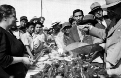 Funcionarios pesando calabazas en el puesto de un mercado durante su inauguración