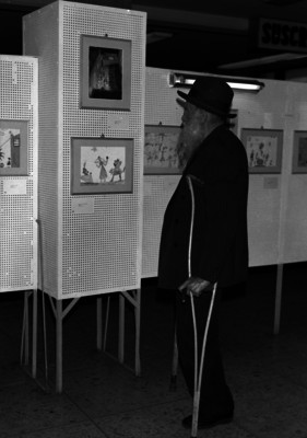 Gerardo Murillo observando dibujos, durante una exposición