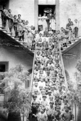 Niños y niñas en las escaleras de una escuela, retrato de grupo