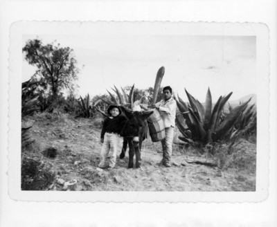 Tlachiquero acompañado de niño en un camino rural