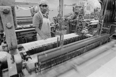Obrero opera máquina en la fábrica textil Miraflores