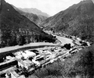 Vista de lago rodeado de casas y montañas