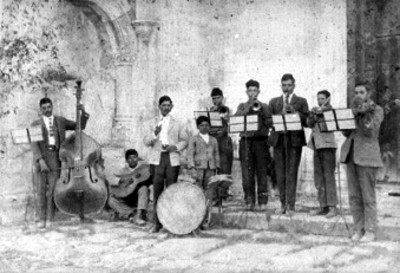 Miembros de banda musical posan para fotografíacon instrumentos musicales, retrato de grupo