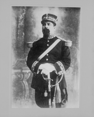Militar de pie y de frente, con su sable apoyado en el suelo