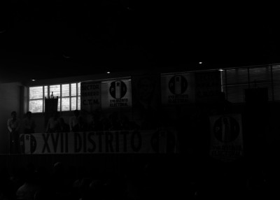 Raúl Noriega y funcionarios ante las palabras de un hombre, durante una asamblea del PRI, en un auditorio
