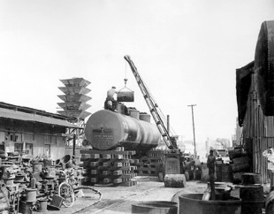 Obreros cargan carro tanque en patios de instalación industrial