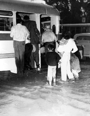 Gente sube a un transporte público durante una inundación a la Colonia "San Cosme"