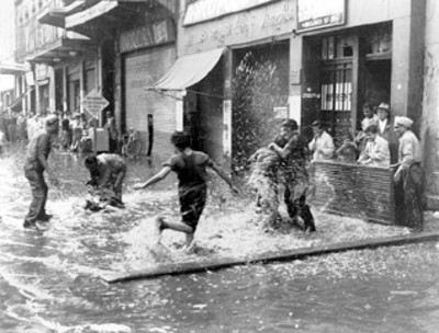Hombres adolescentes juegan en una calle inundada
