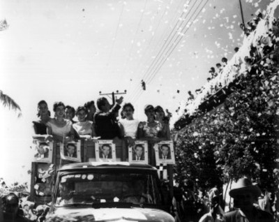 Adolfo López Mateos con mujeres en un camión, saluda durante su campaña electoral